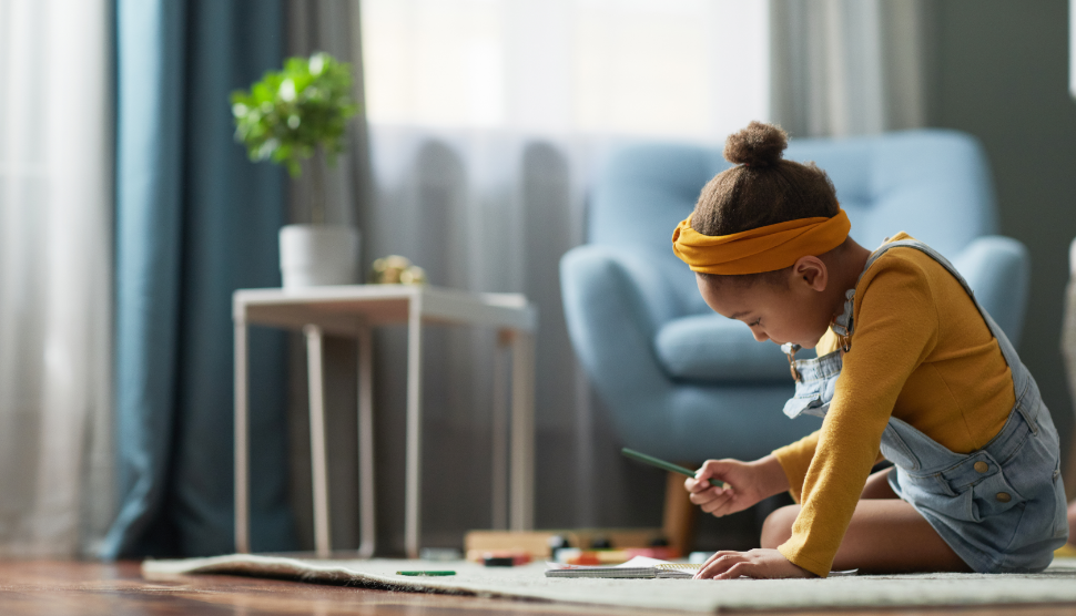 Side-view-portrait-of-cute-African-American-girl-drawing-while-sitting-on-floor-in-cozy-home-interior-copy-space